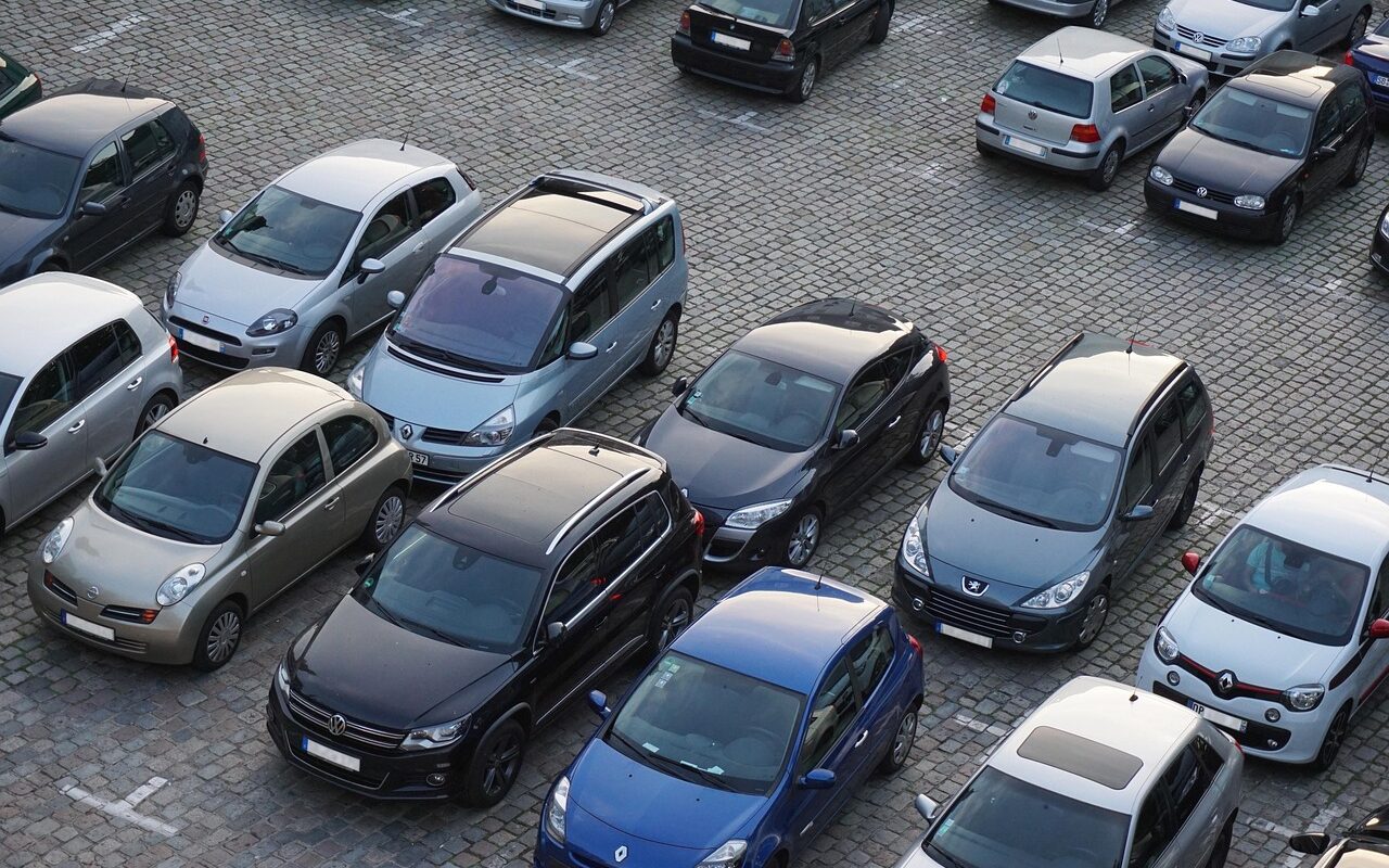 Différentes voitures garées sur un parking.